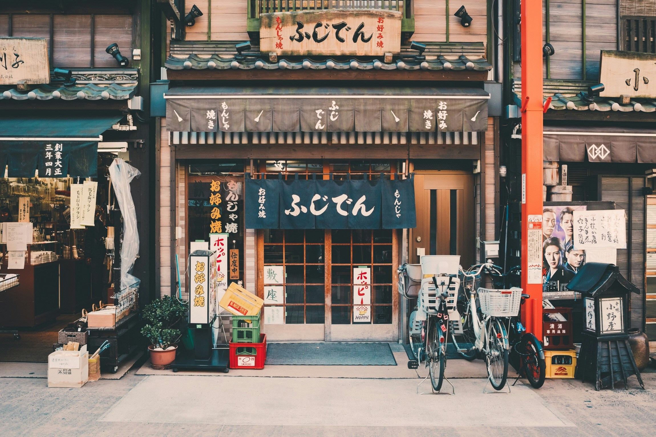 Fachada de un establecimiento japonés con carteles y un 'noren' (cortina tradicional japonesa) en la entrada